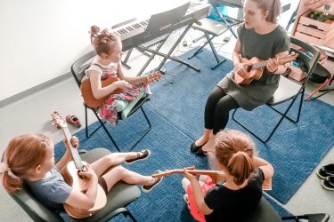 zdjęcie instruktorki i dzieci grające na ukulele