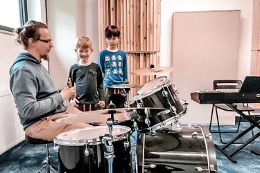 zdjęcie instruktor i dzieci podczas warsztatów muzyczne, perkusja